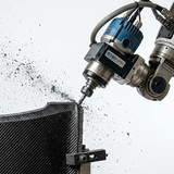 FRP/樹脂製品の端部を高速回転するルーターアタッチメントで切削トリミングしている加工自動化システムの実写写真